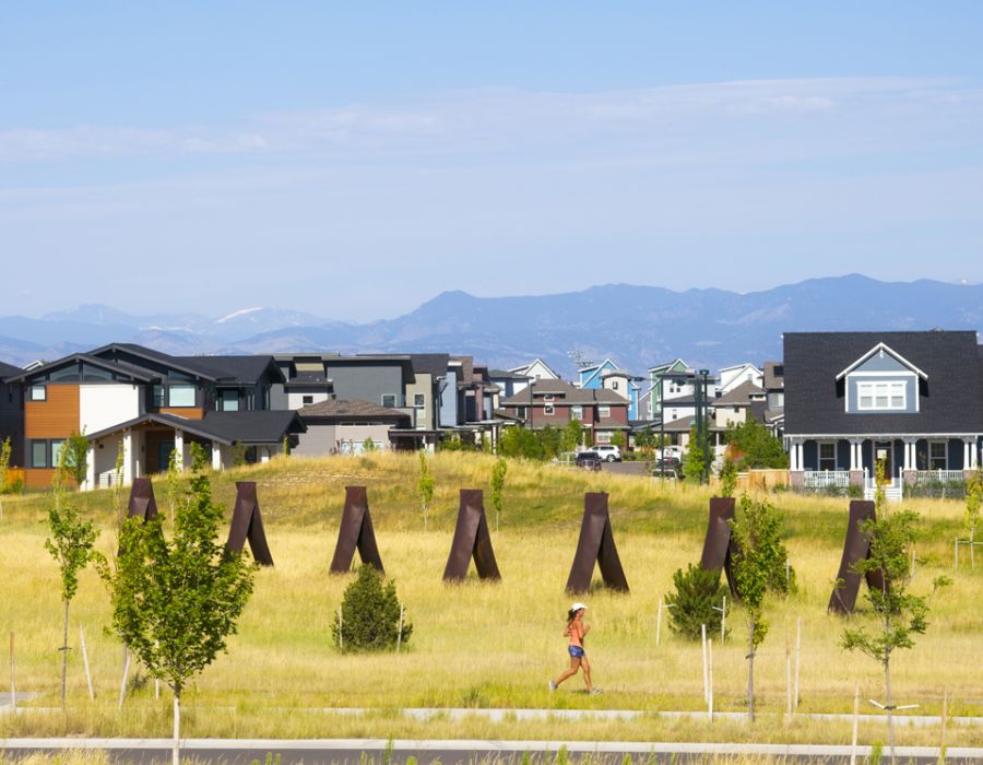 Running path alongside residential community with Rocky Mountains in background