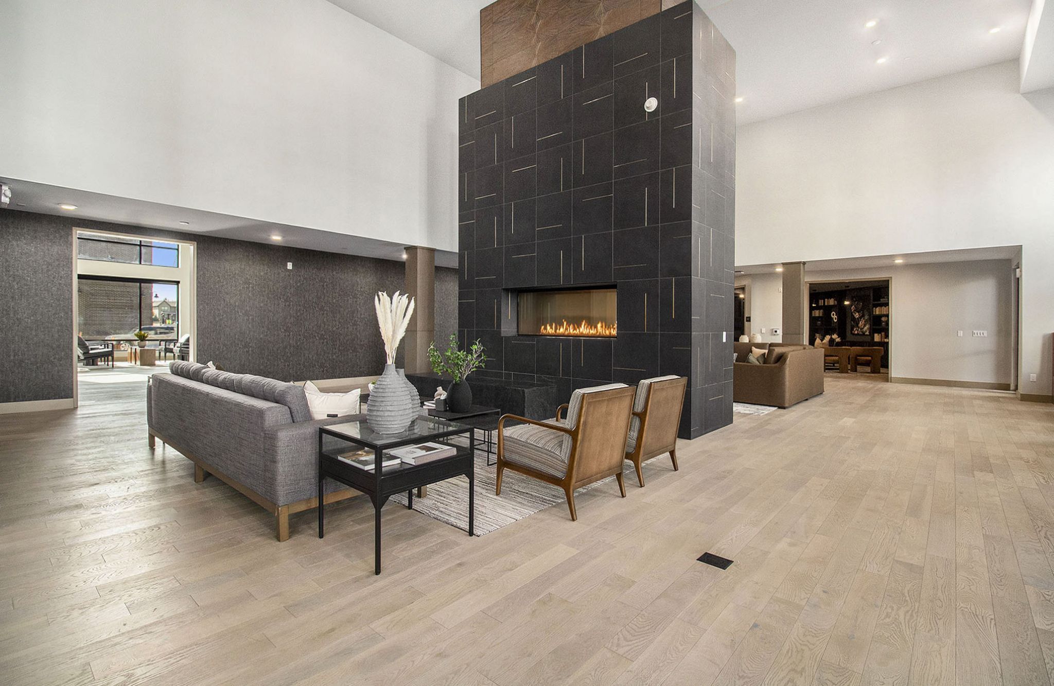 A spacious, contemporary living area at Solana Central Park with a central fireplace, modern seating, and neutral tones throughout.