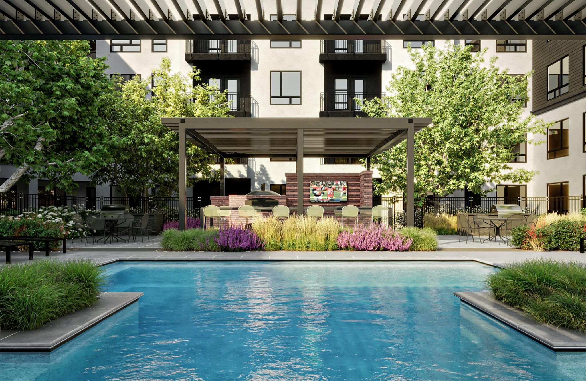 A luxurious pool area at Solana Central Park features a pergola with lounge seating and a lush green landscape.