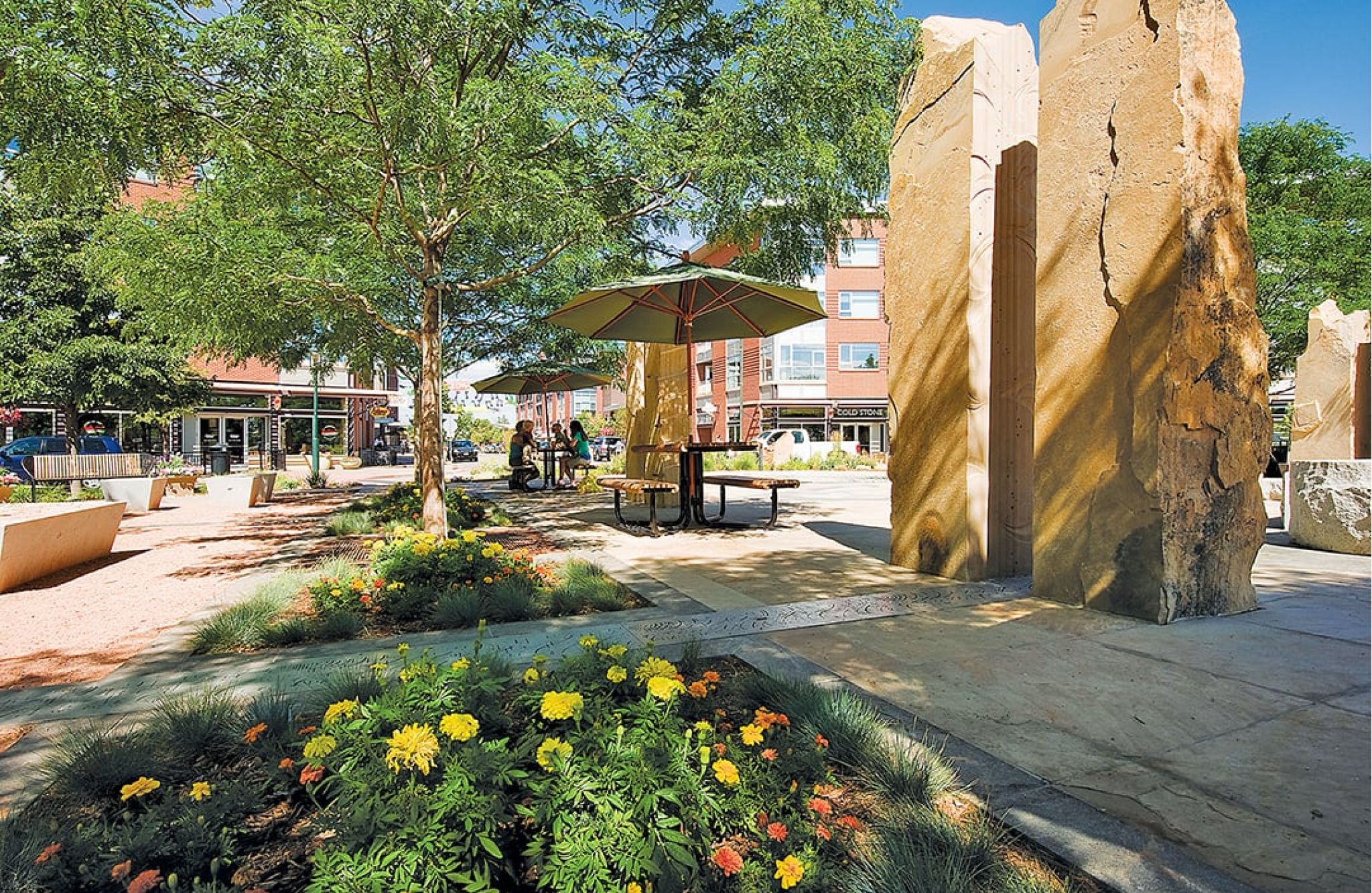 Beautiful outdoor seating area in public plaza with flowers and rock sculptures