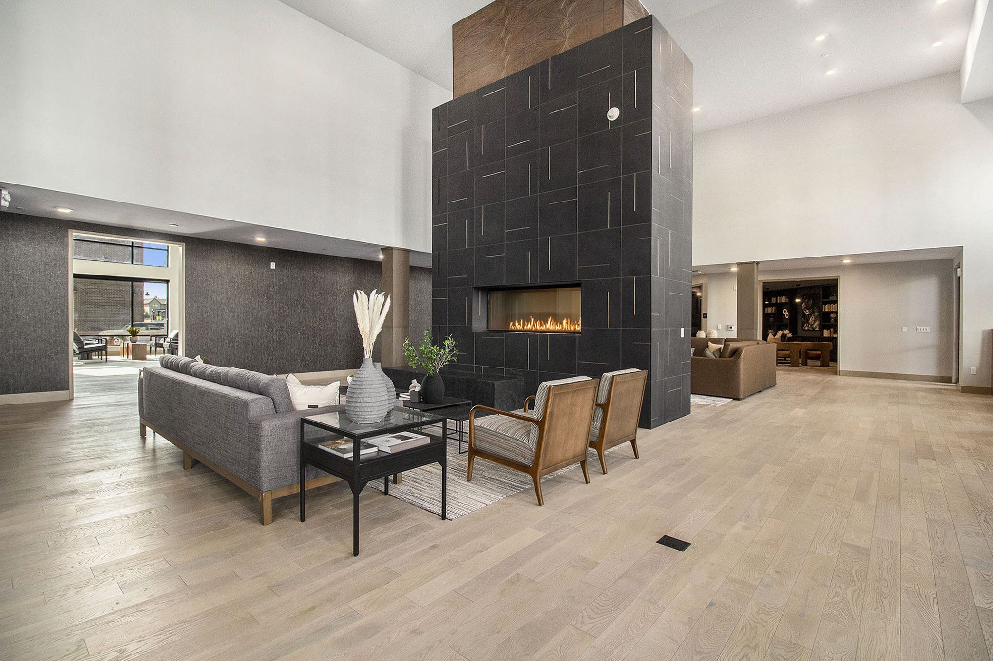 A spacious, contemporary living area at Solana Central Park with a central fireplace, modern seating, and neutral tones throughout.