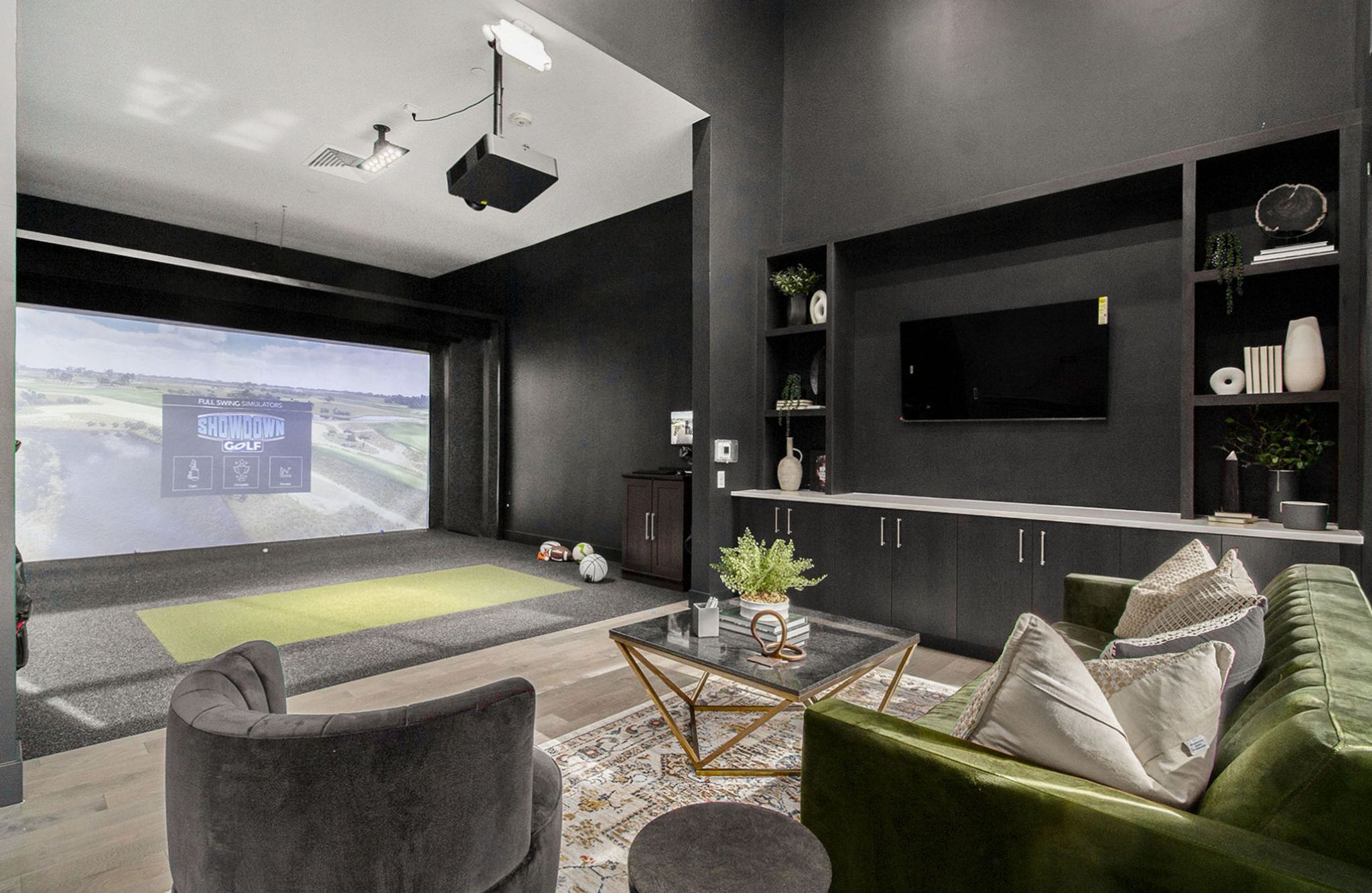 A sleek game room in Solana Central Park featuring a golf simulator, black walls, and modern seating.