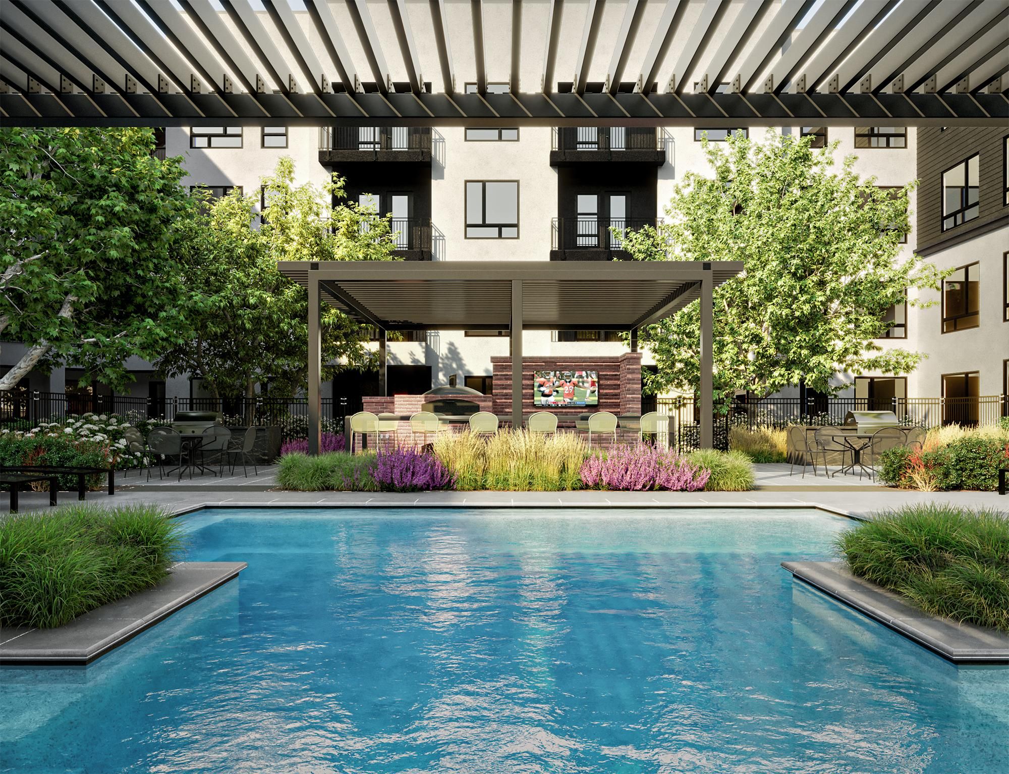 A luxurious pool area at Solana Central Park features a pergola with lounge seating and a lush green landscape.