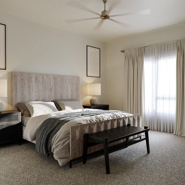 A well-appointed bedroom at Solana Central Park featuring a neutral color palette with a large bed and upholstered headboard against a light wall.