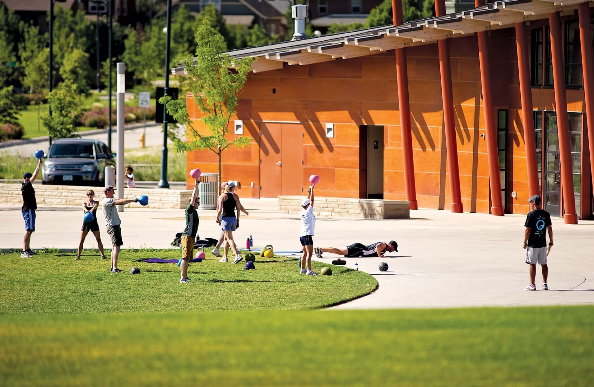 Outdoor fitness class with people swinging kettlebells